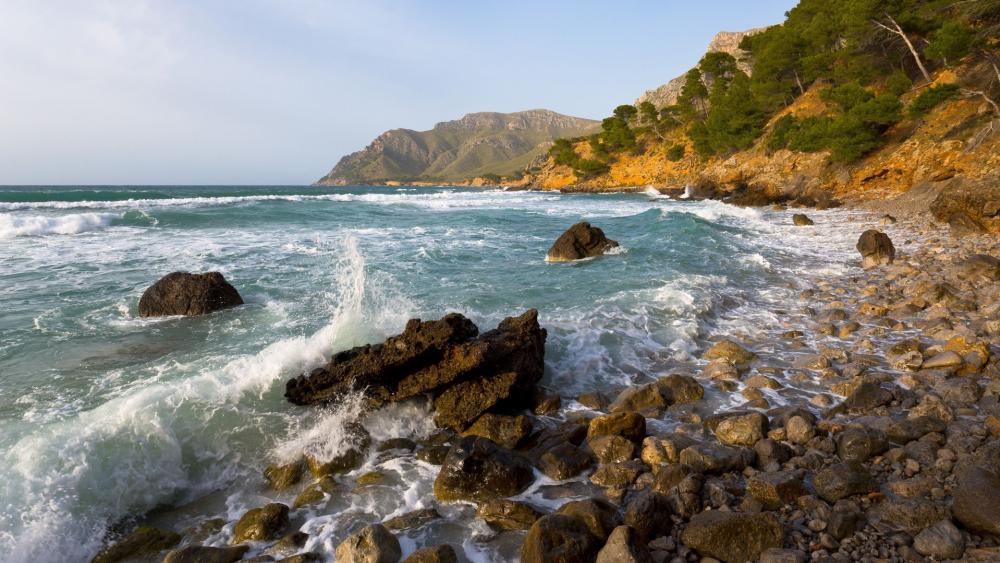 Serene Coastal Landscape with Rocky Shoreline and Waves wallpaper