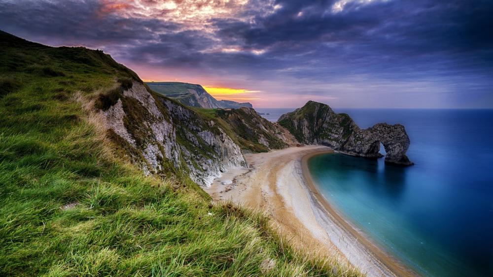 Serene Coastal Sunset Overlooking Dramatic Cliffs wallpaper