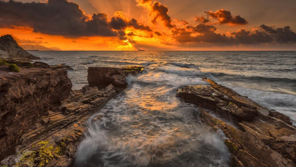 Golden Sunset Over Rocky Shoreline wallpaper