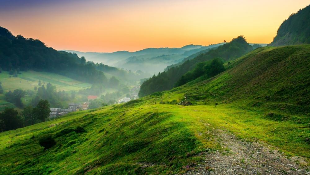 Serene Sunrise Over Lush Green Hills wallpaper