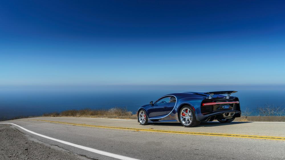 Sleek Car on a Scenic Coastal Road wallpaper