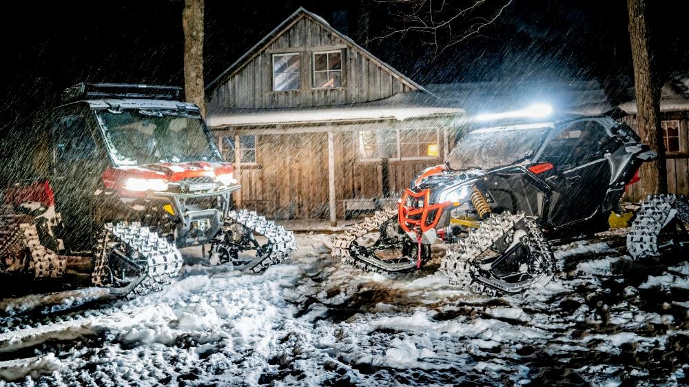 Powerful Snowmobiles in a Winter Wonderland Scene wallpaper