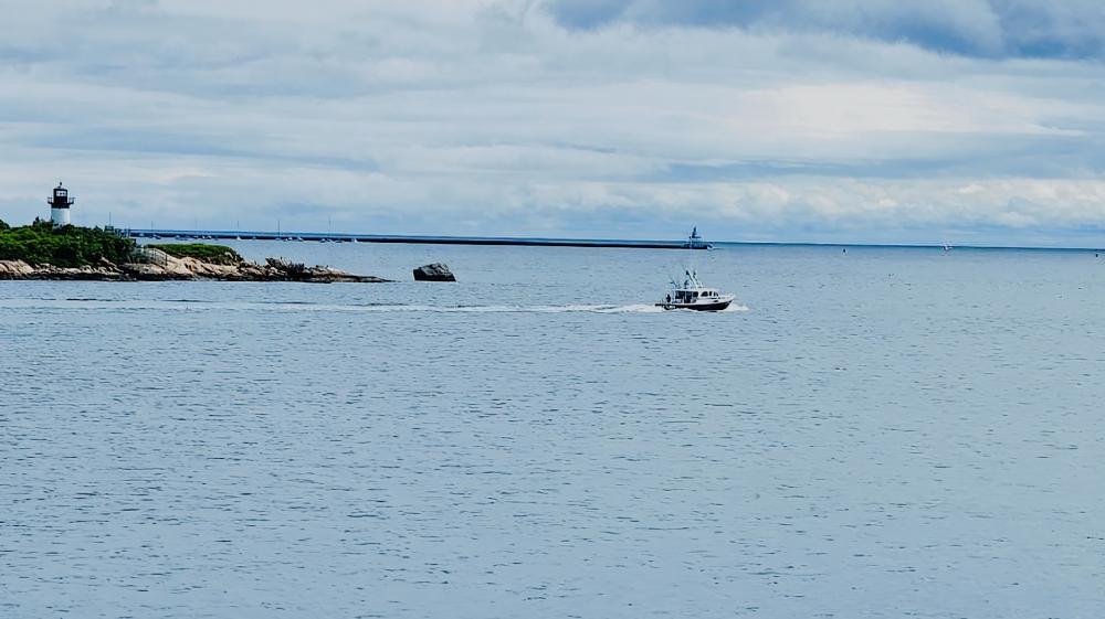 Ocean Serenity with Lighthouse and Boat Scene wallpaper