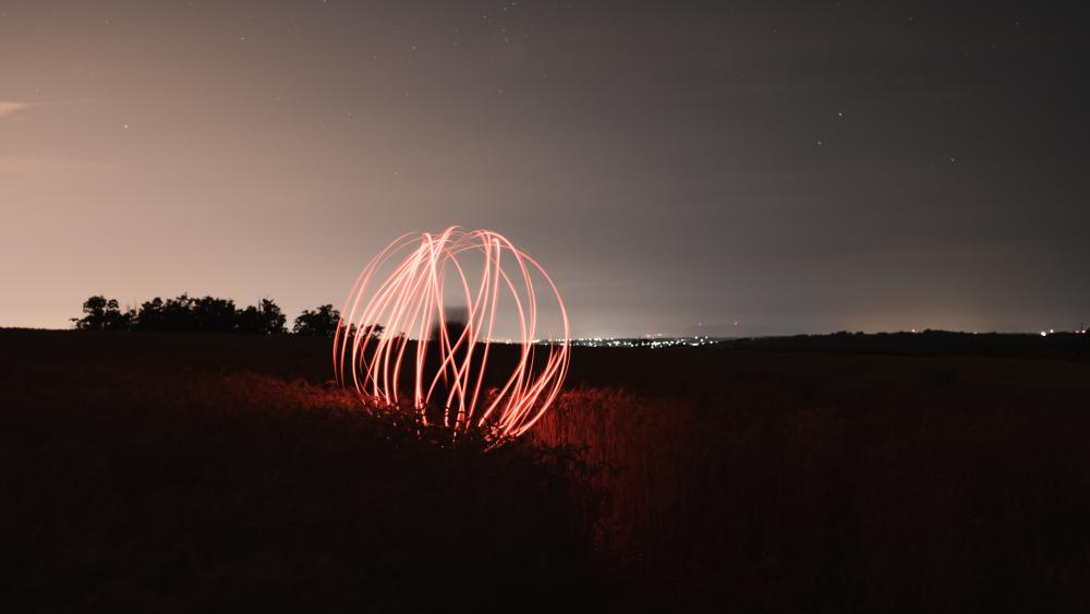 Mystical Orb of Light in Nighttime Field wallpaper