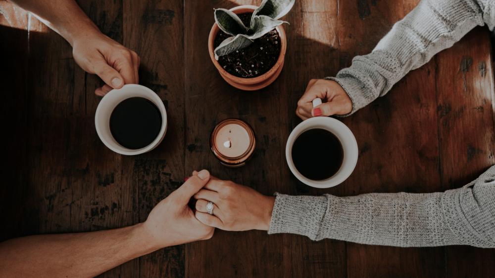 Holding hands during morning coffee wallpaper