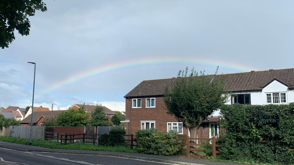 A rainbow over a house wallpaper