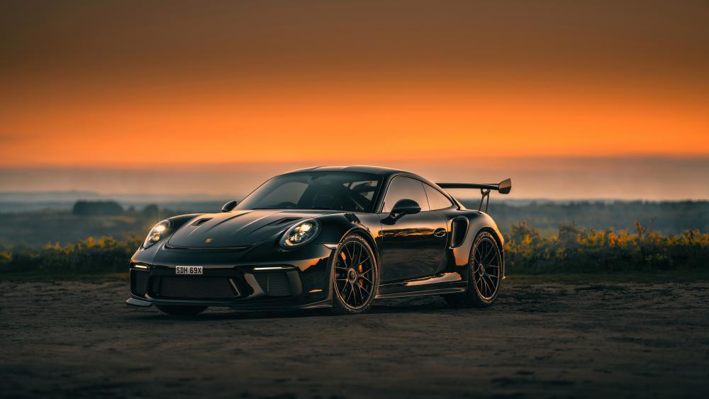 Sunset Embrace with a Black Porsche 911 GT3 Sports Car wallpaper