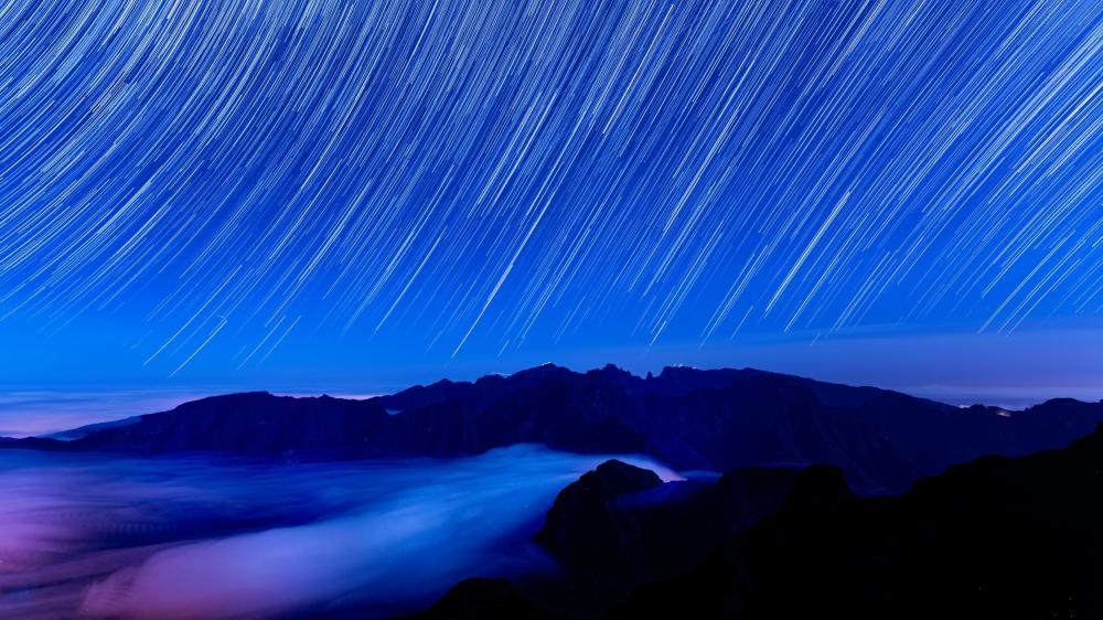 Starry Trails Over Misty Mountains wallpaper