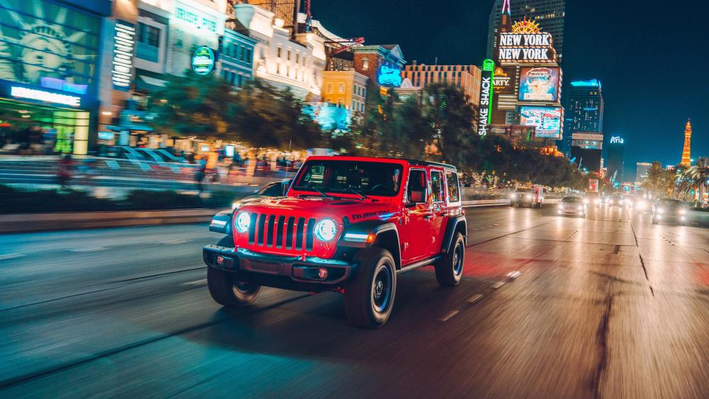 Red Jeep Cruising The Vibrant Nightlife wallpaper