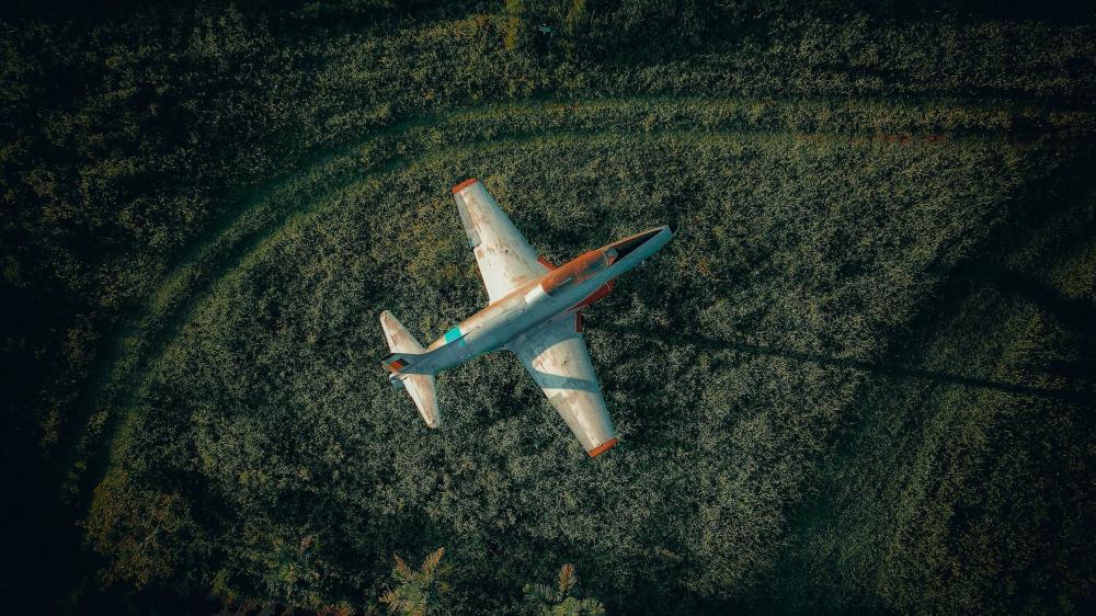Aerial View of Aircraft Over Verdant Landscape wallpaper