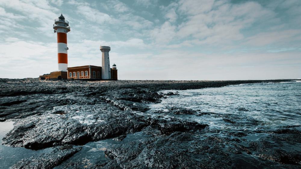Faro de Tostón Lighthouse Guardian of Rocky Shores wallpaper