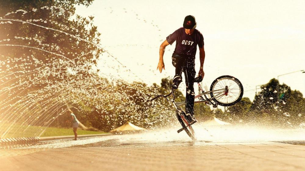 Bike Tricks Amidst a Watery Arc wallpaper