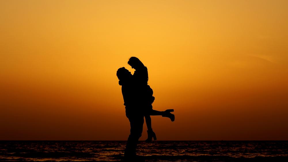 Romantic Silhouette of Couple at Sunset Beach wallpaper