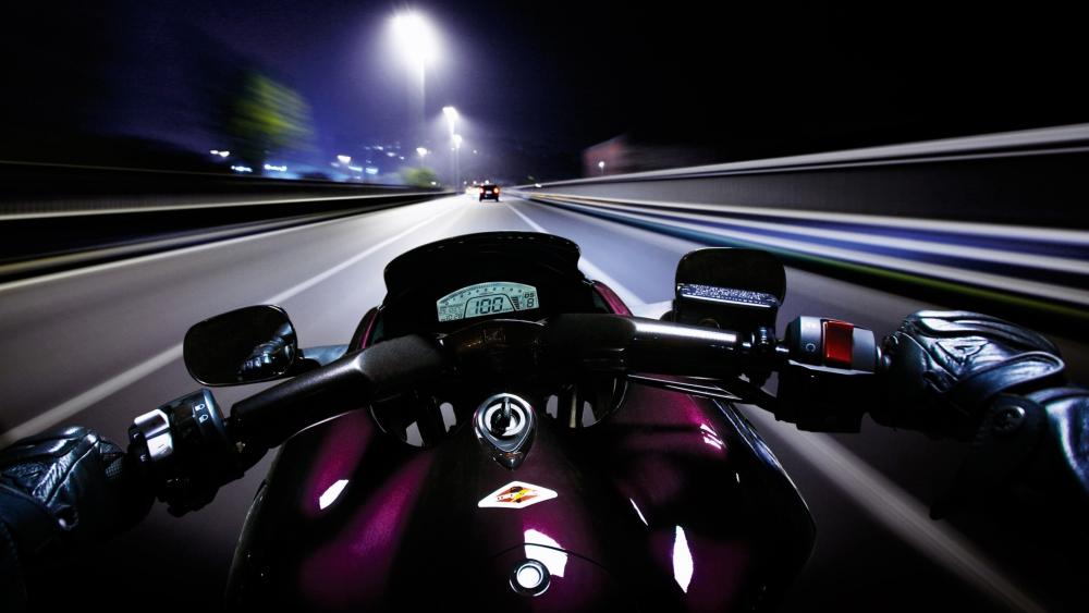 Racing Through the Night on a Speedy Motorcycle wallpaper