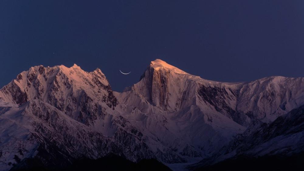 Majestic Crescent Over Snowy Peaks wallpaper