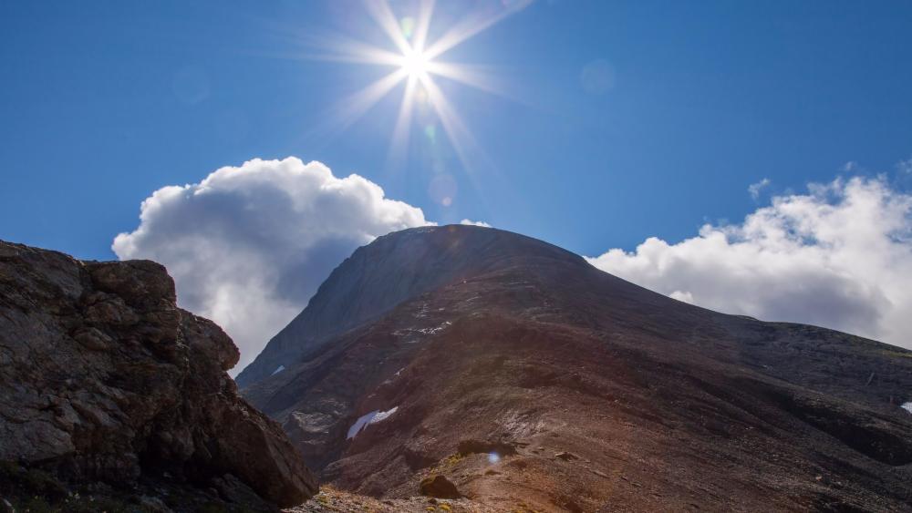 Radiant Sunlight Over Mountain Slope wallpaper