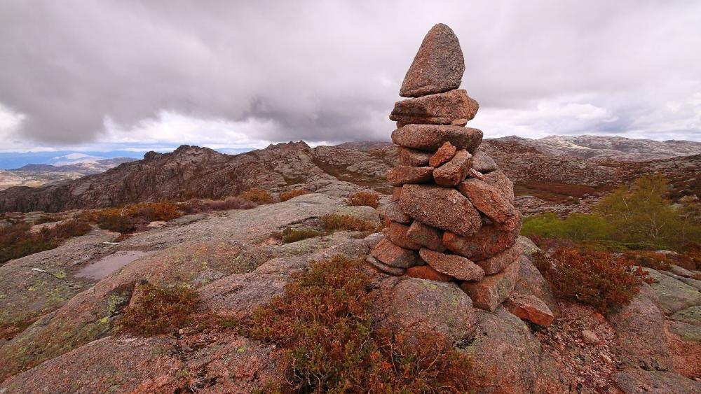 Stone Balance Amidst Rugged Landscape wallpaper