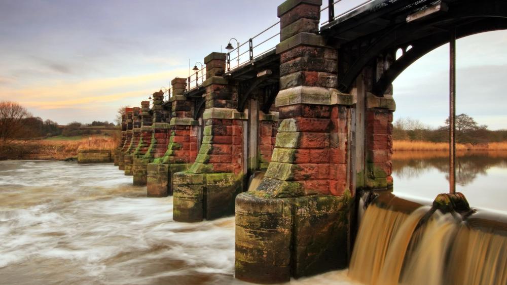 Timeless Stone Bridge Over River Rapids wallpaper