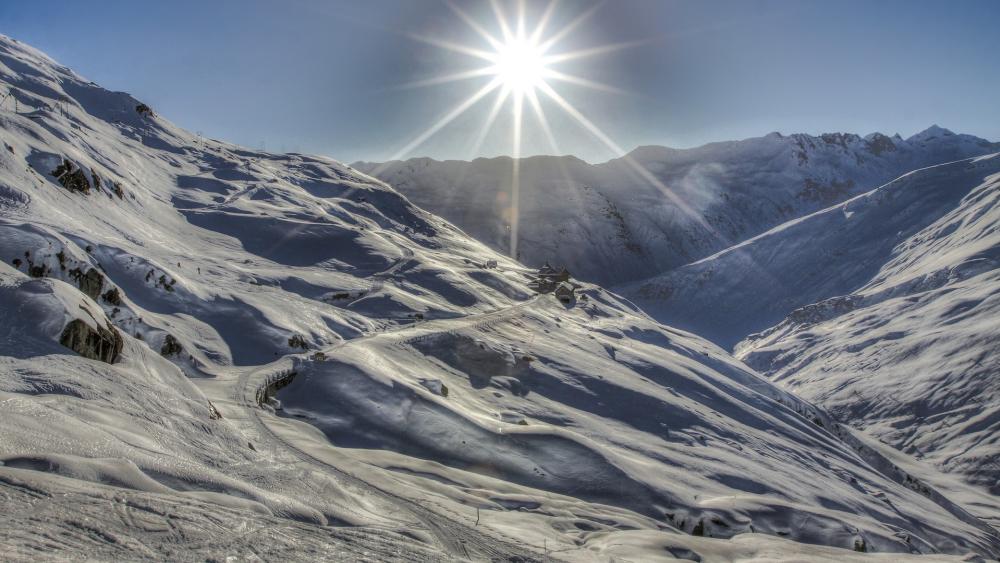 Winter Sunburst Over Snowy Alpine Peaks wallpaper