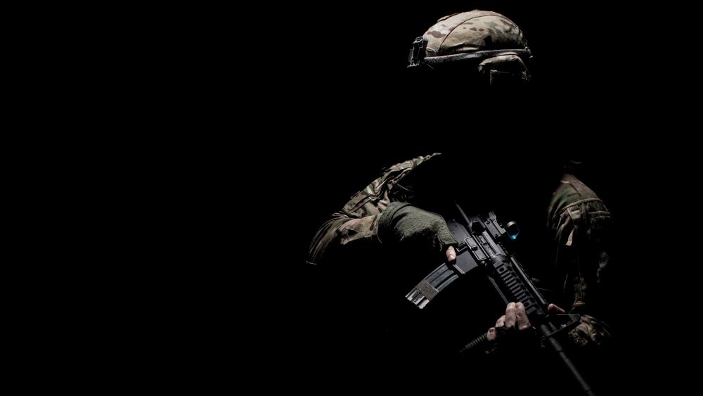 Military Silhouette in Camouflage Holding Machine Gun wallpaper