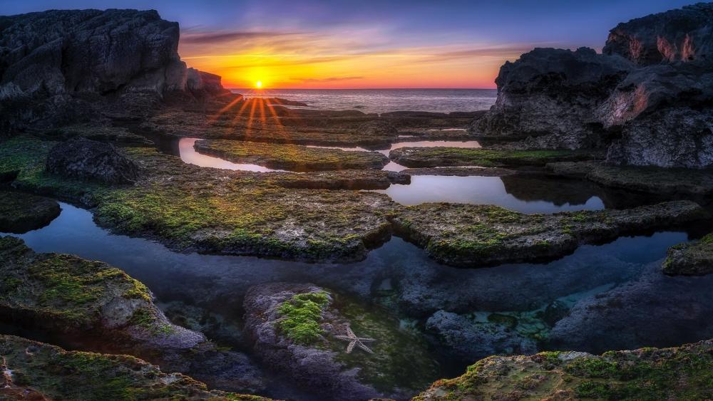 Sunset Serenity Over Rocky Shores wallpaper