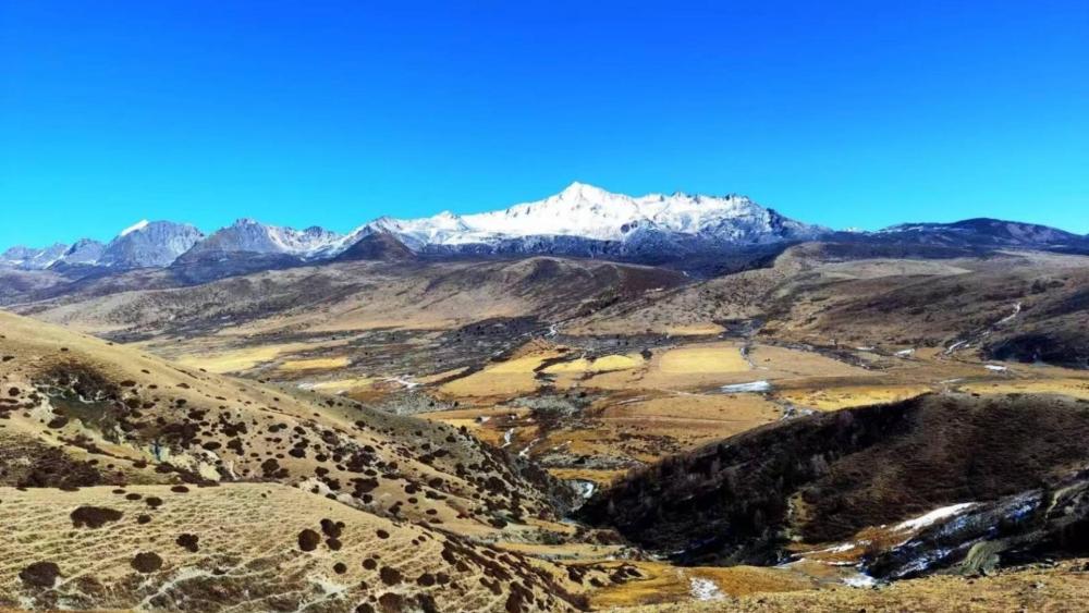 Snow-Capped Mountains and Sandy Terrain in China wallpaper