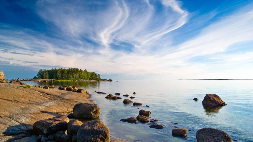 Tranquil Lakeside Serenity: Rocky Shores and Azure Sky wallpaper
