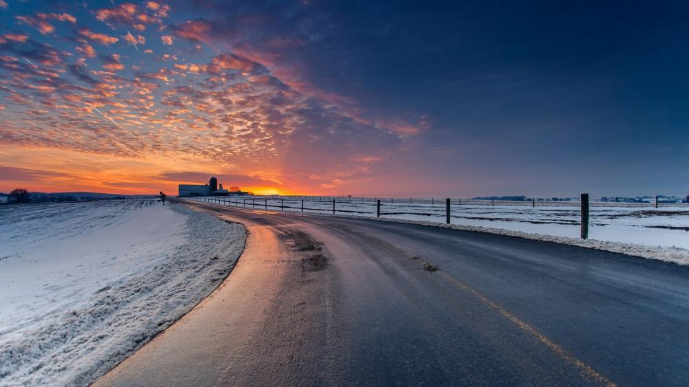 Winter Road at Sunset Embraced by Snowy Serenity wallpaper