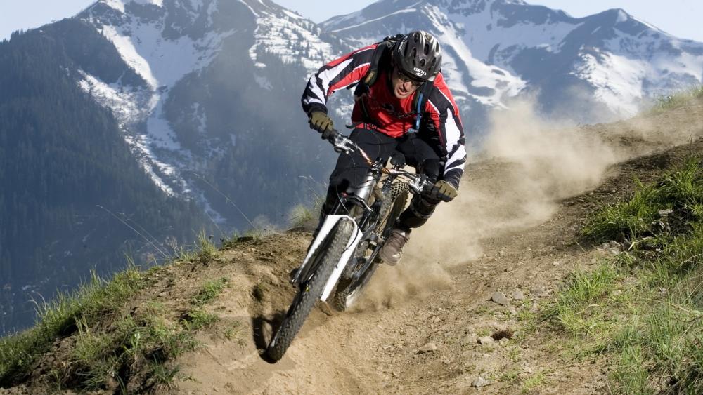 Thrilling Downhill Mountain Biking Adventure wallpaper