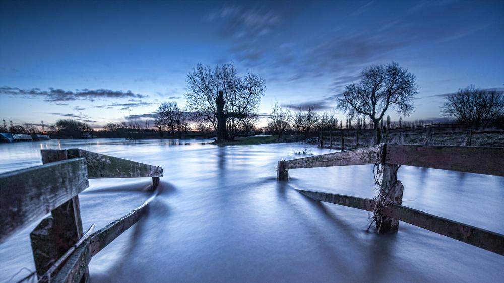 Fenced Pathway Leading into Misty Waters at Dusk wallpaper