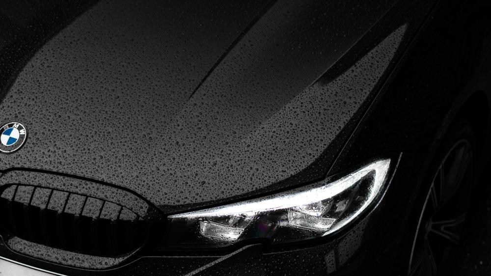 Sleek Black BMW in Rainy Elegance wallpaper
