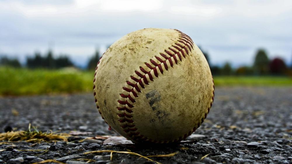 Baseball on Rough Ground Captures Game Spirit wallpaper
