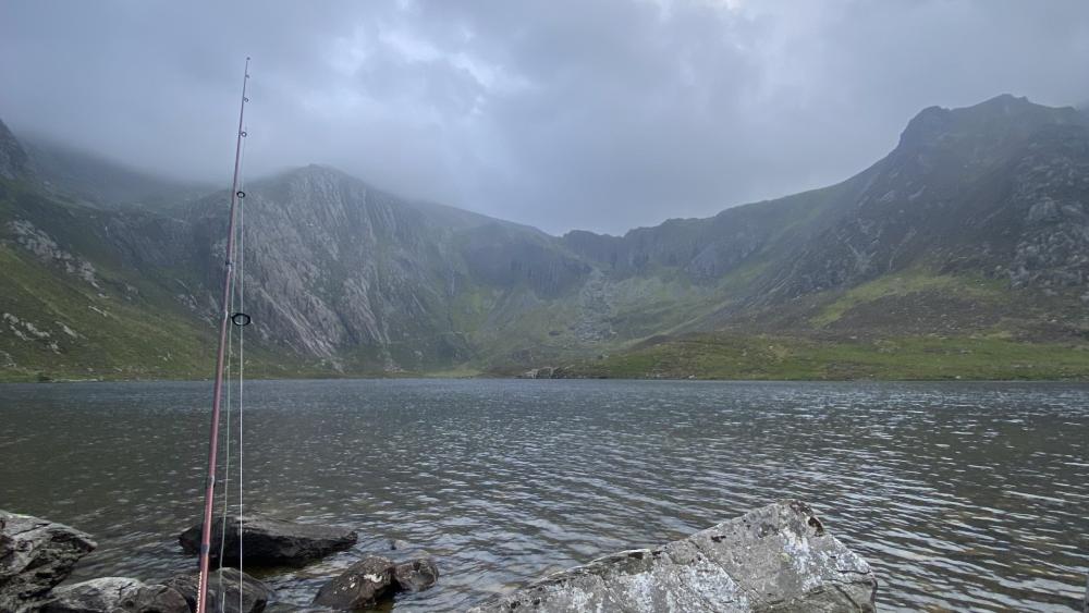 Serene Fishing Lake in Misty Mountains wallpaper