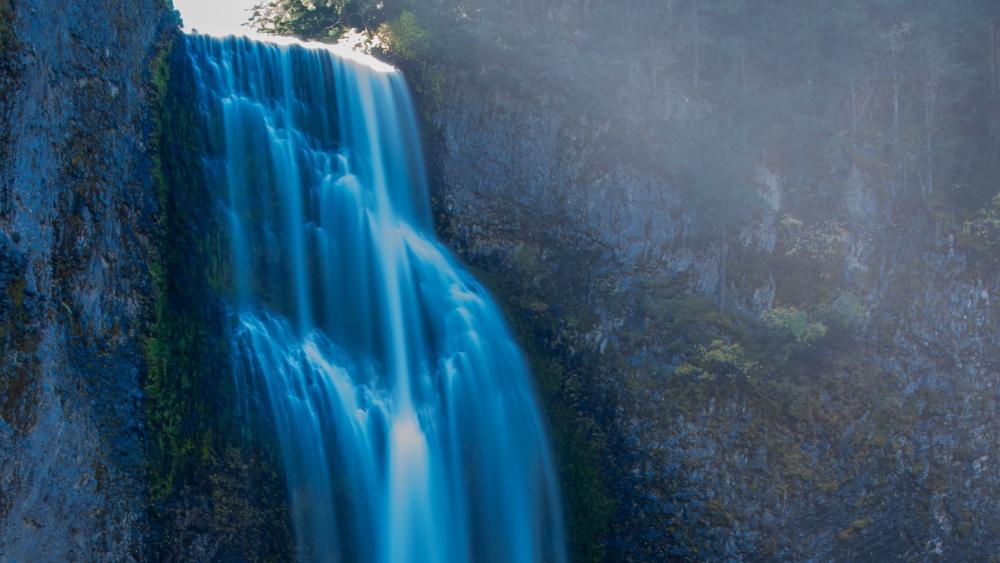 Majestic Cascade in a Serene Forest Setting wallpaper