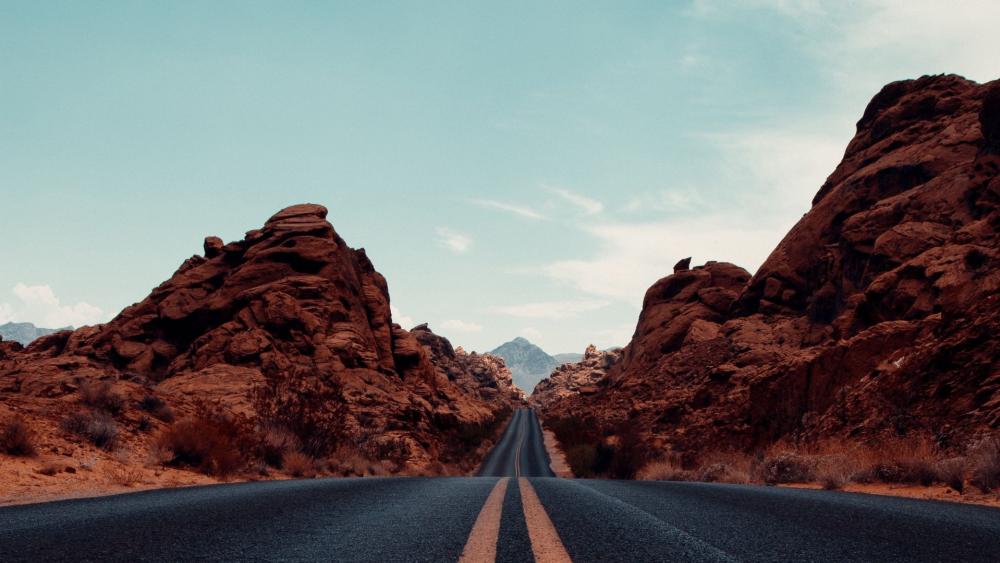 Road Through Majestic Red Rock Formations in Nevada's Wilderness wallpaper