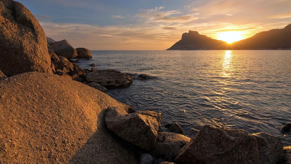 Golden Sunset Over Rocky Shoreline wallpaper
