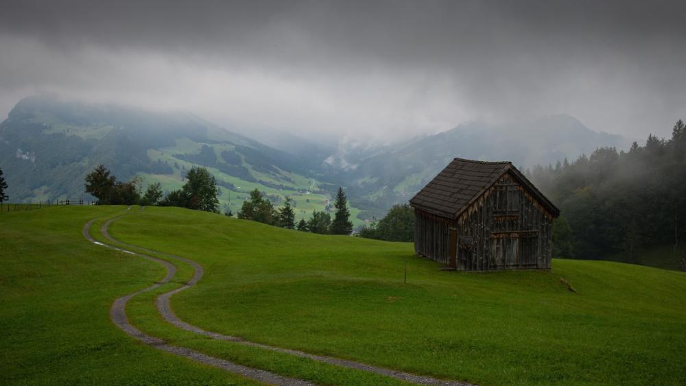 Rustic Cabin Amid Misty Hills wallpaper
