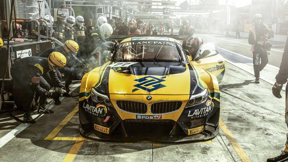 High-Speed Pit Stop in Motorsport Action wallpaper