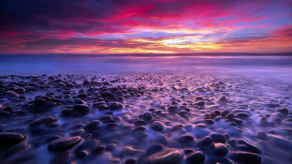 Serene Twilight Over Pebbled Shoreline wallpaper