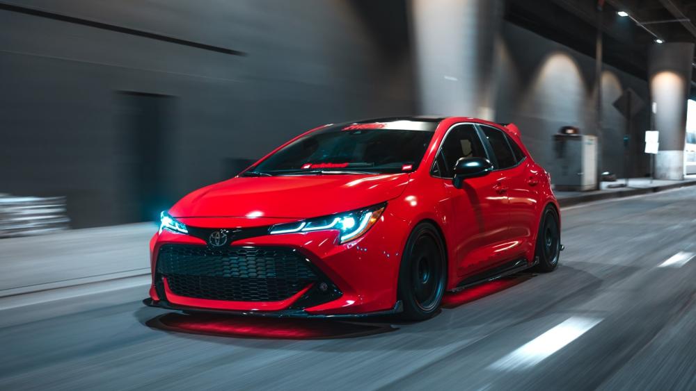 Red Hot Hatchback Racing Through Midnight City Streets wallpaper