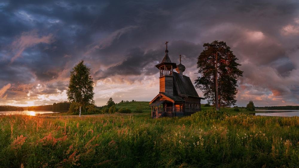 Stormlit Sunset Over a Wooden Chapel in Rural Arkhangelsk wallpaper