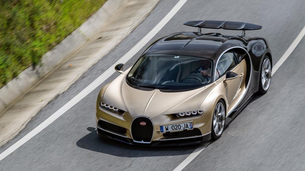 Golden Bugatti Chiron in Motion on Open Road wallpaper