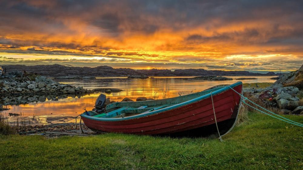 Moored Boat Beneath a Burning Sky on a Quiet Shore wallpaper