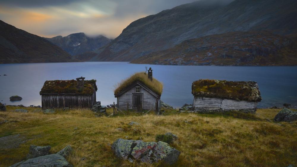Turf Roof Huts by a Still Lake in Gaularfjellet Norway wallpaper