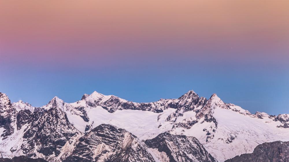 Pastel Dawn Over Snowy Alpine Ridge and Jagged Winter Summits wallpaper