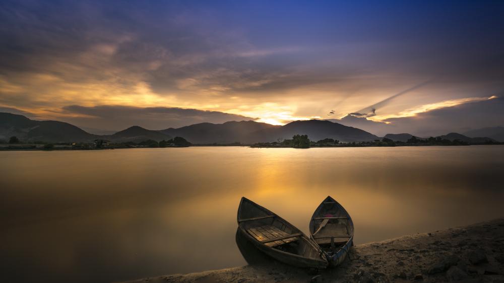 Silent Boats Resting on a Tranquil Lake at Golden Dusk wallpaper
