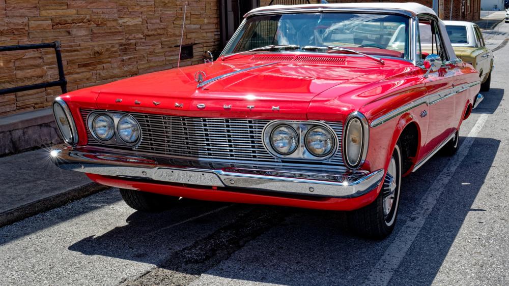Red Plymouth Classic Muscle Car Gleaming in Sunlit Street wallpaper