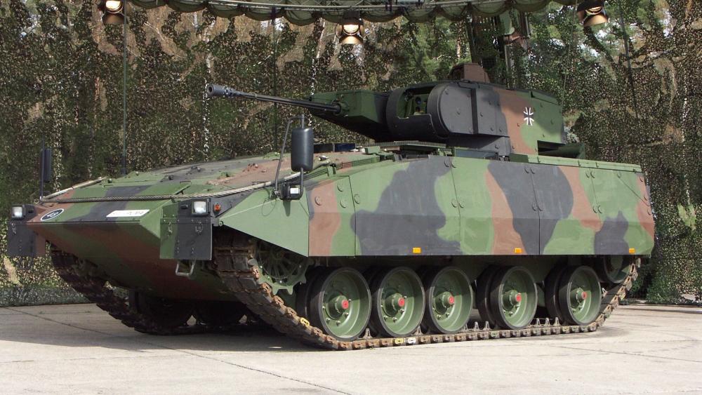 Camouflaged Armored Combat Vehicle Displayed Under Field Canopy wallpaper