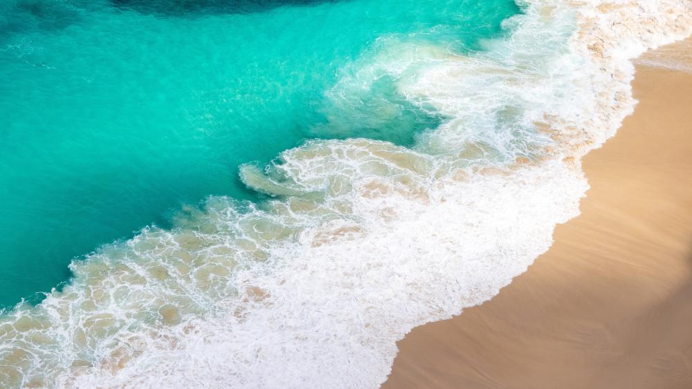 Turquoise Ocean Waves Meeting Golden Sand In Aerial Serenity wallpaper