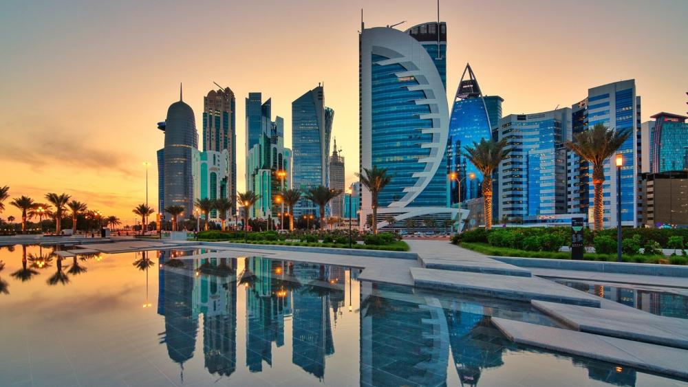 Doha West Bay Skyline Reflected in Sunset Waters wallpaper